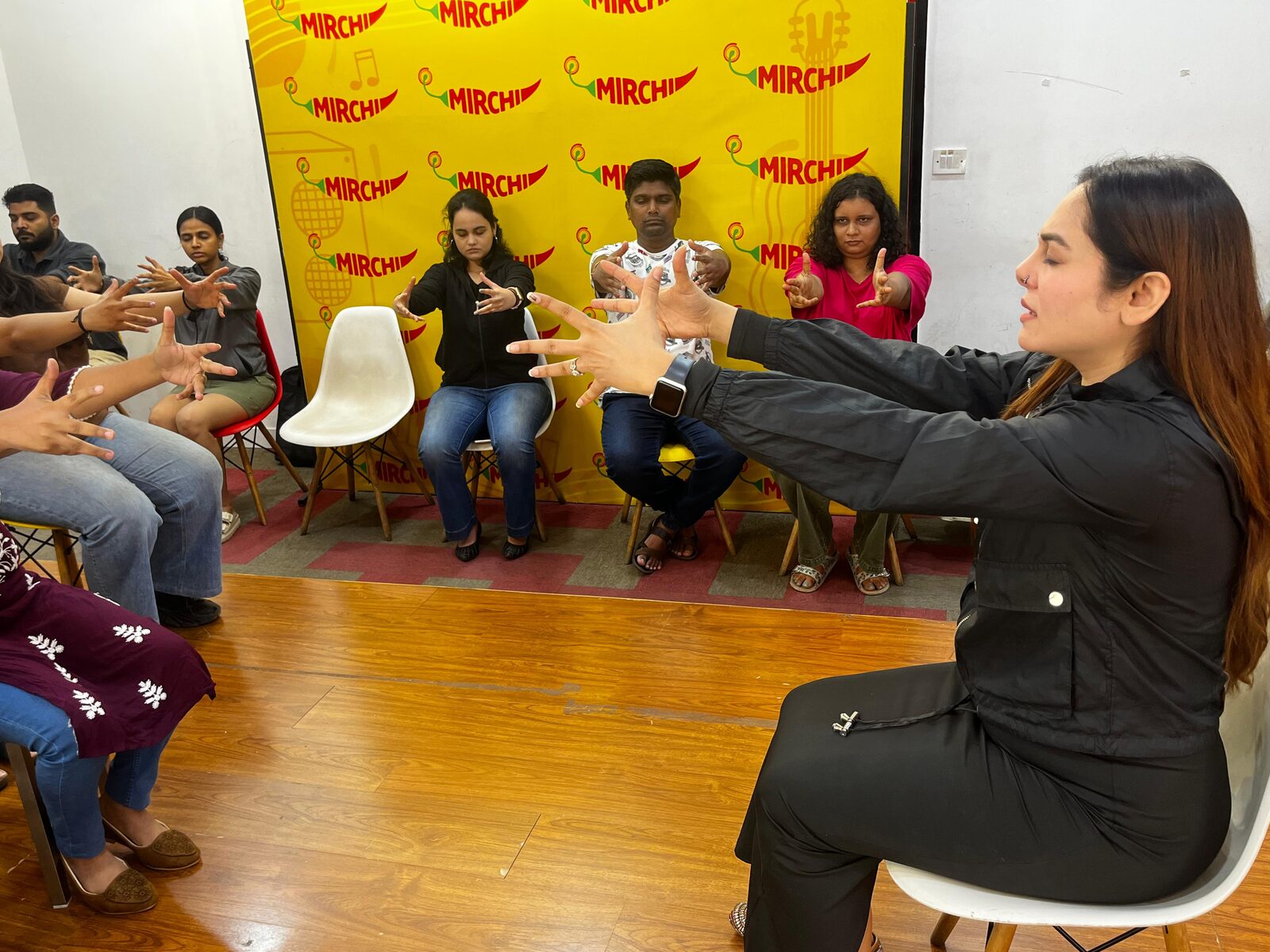 Vibha Jain leading a group hypnotherapy demonstration, guiding participants through a focused-attention exercise