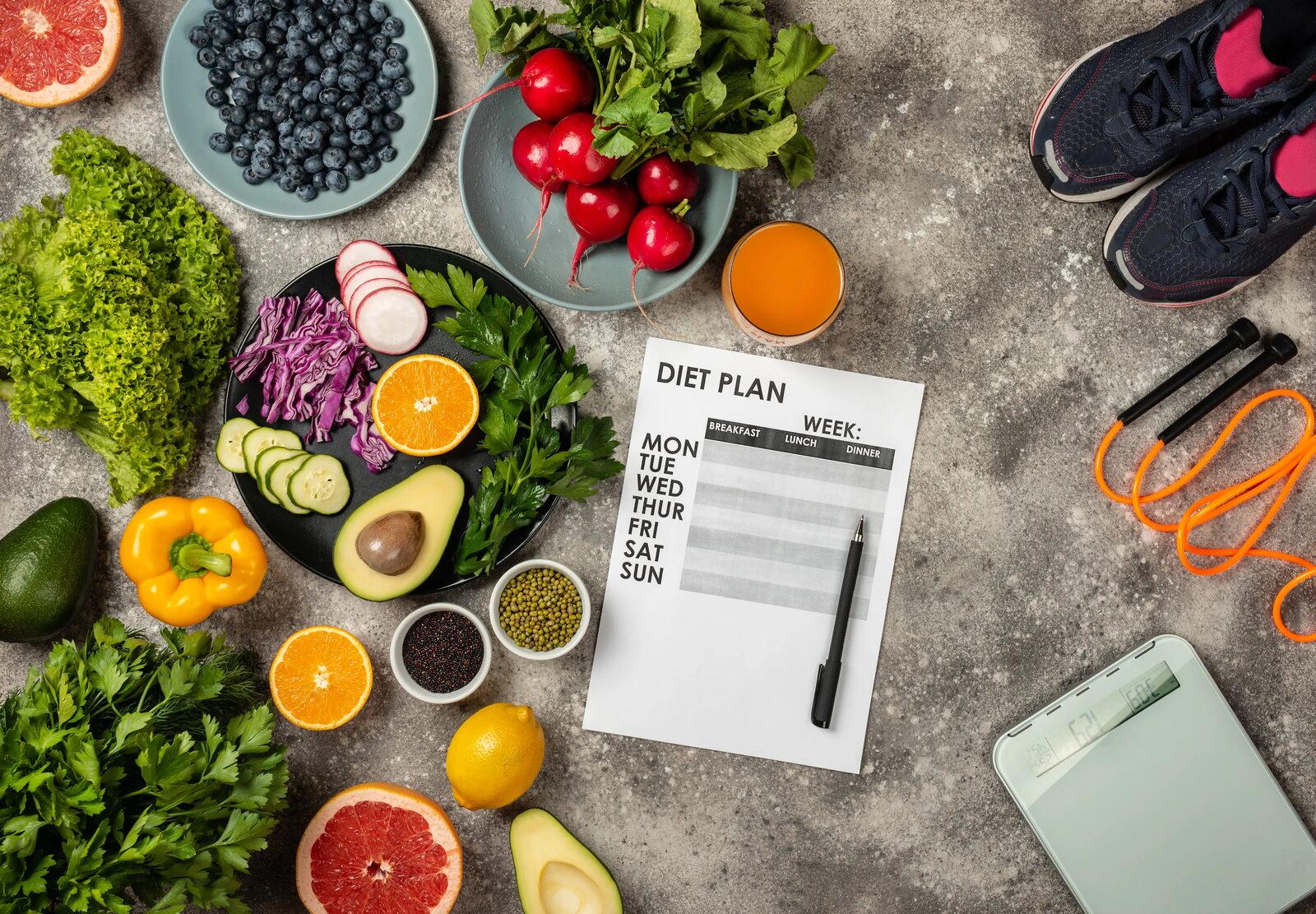 Fresh vegetables, fruit and a written weekly plan laid out together on a work surface